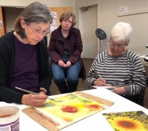 Mary Anderson showing watercolor techniques to students